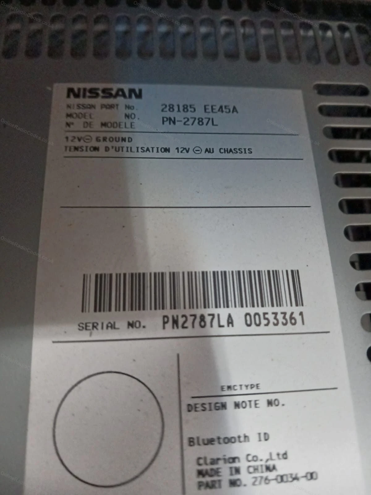 White barcode label with the serial number on a Nissan unit